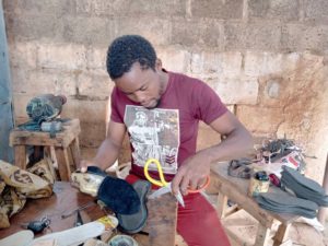 Hamado Nana en train de fabriquer une chaussure Hana